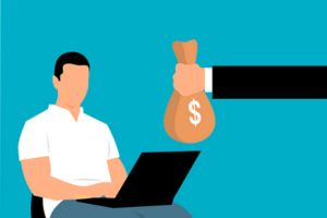 uomo al computer che riceve un sacco di euro