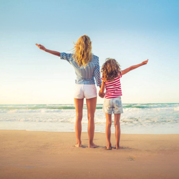 mamma e figlia in spiaggia che guardano l'orizzonte viste di spalle