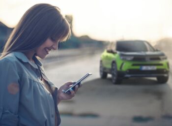 ragazza al cellulare con city car sullo sfondo