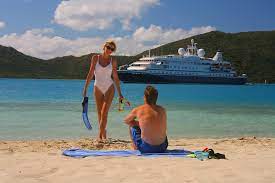 donna e uomo su spiaggia con nave su sfondo